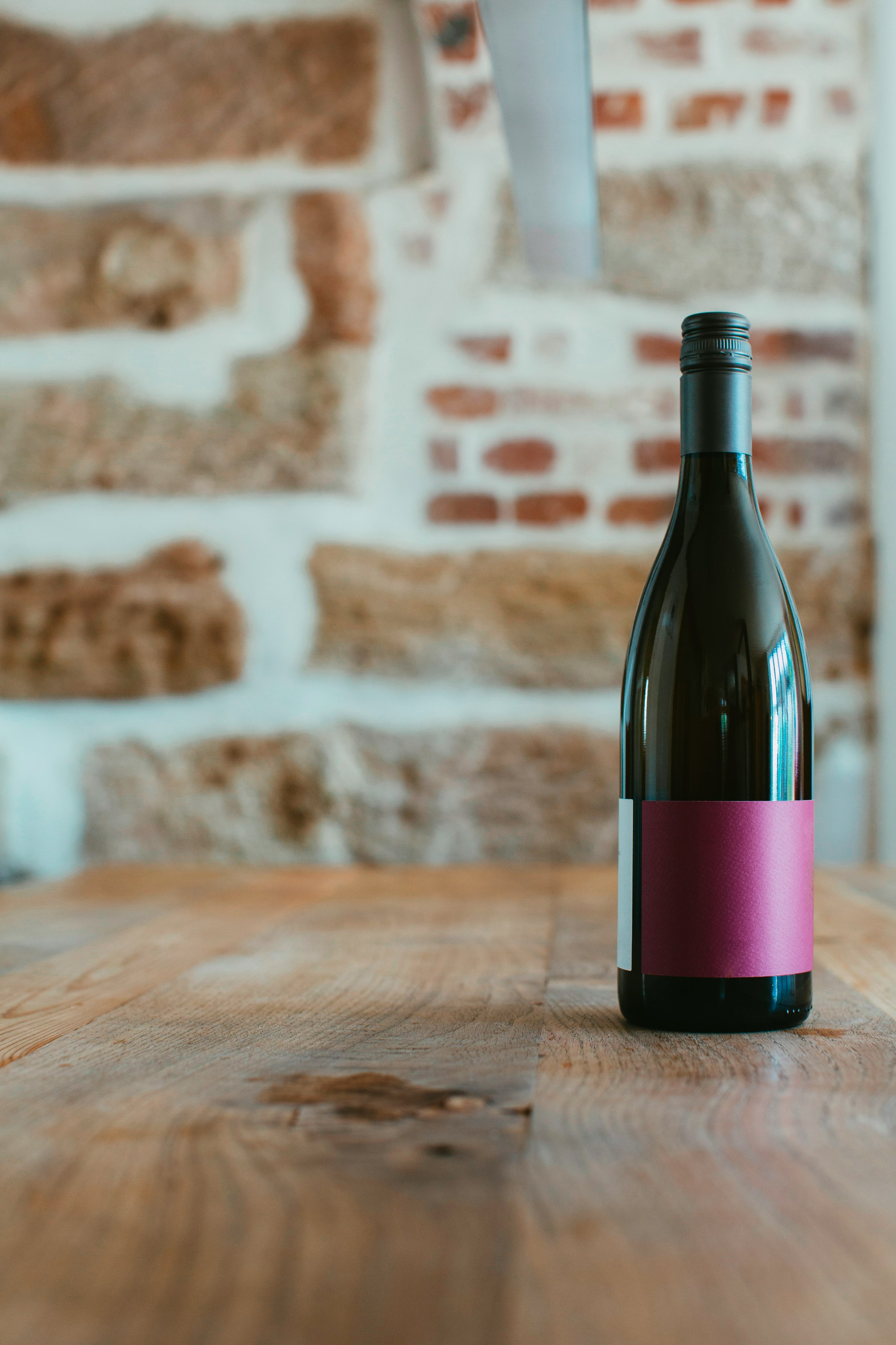 black and pink bottle on brown wooden table